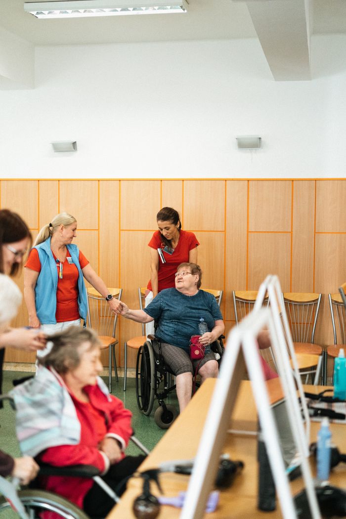Services Healthcare professionals interact with elderly individuals in a care facility.