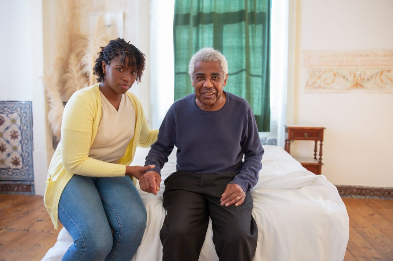 Services Daughter supporting elderly father in a bright, cozy room filled with love and warmth.