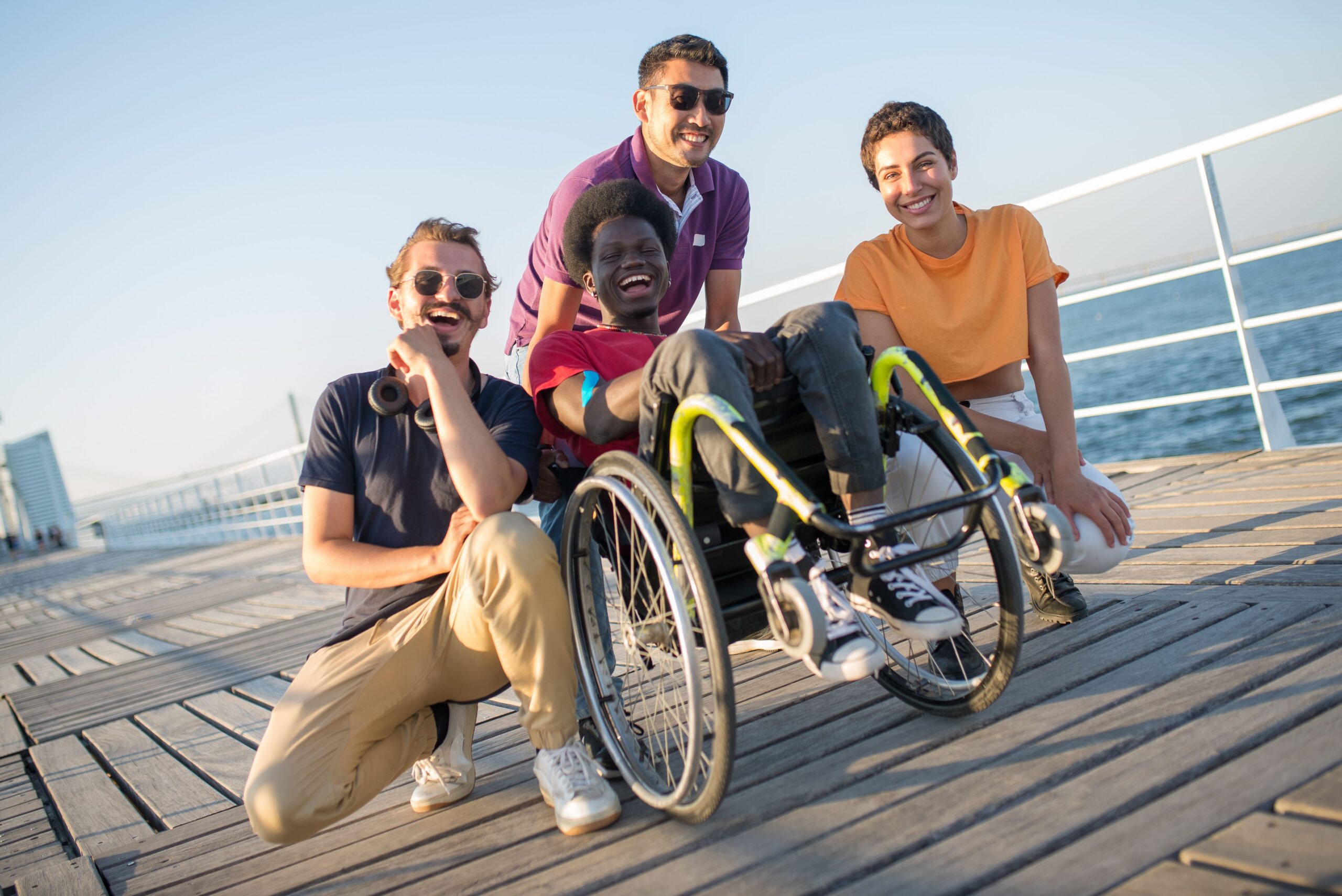 Home Group of friends with diverse backgrounds having fun by the water in Portugal, embracing inclusivity and joy.